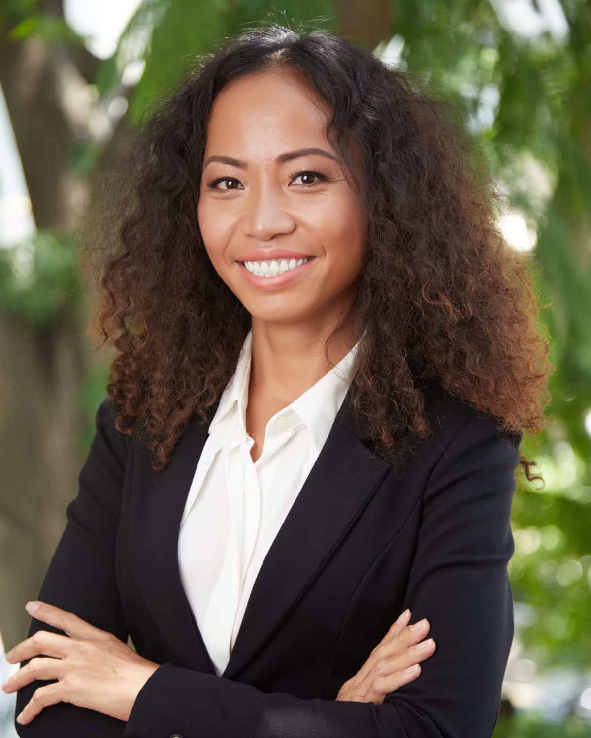 A smiling attorney in a black suit outdoors