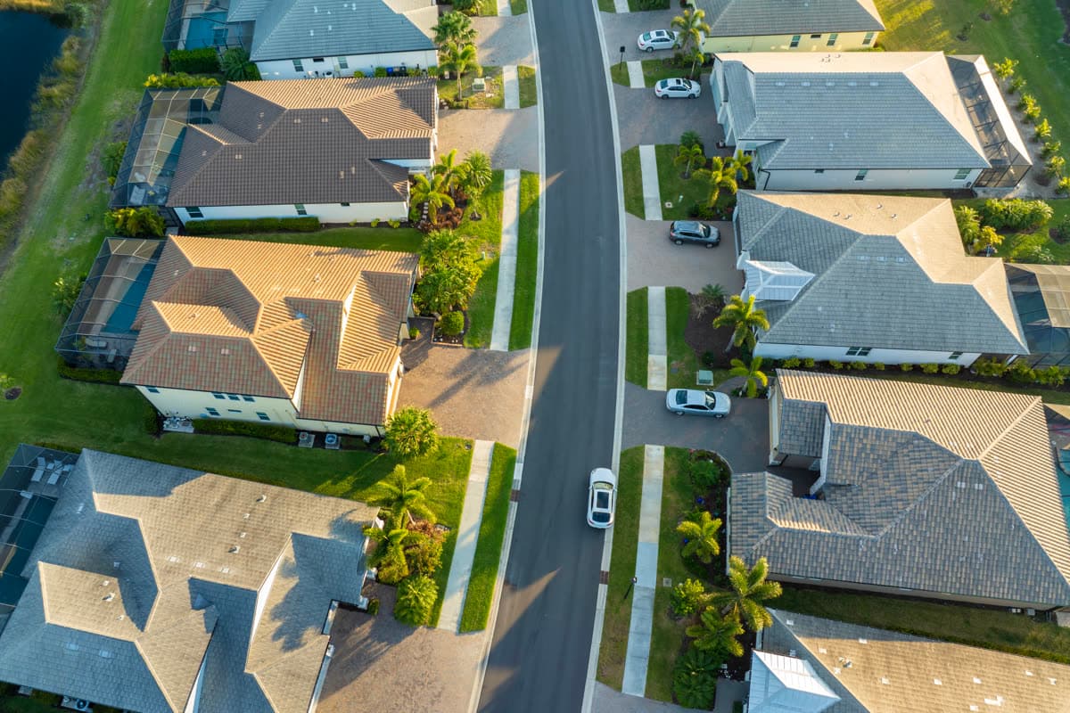 Aerial view of a suburban street lined with tile-roofed homes
