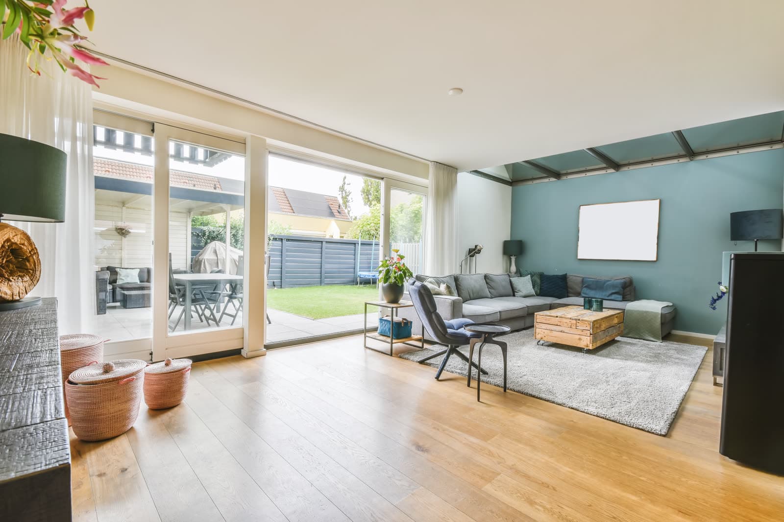 A bright living room with wood floors and glass doors to a garden