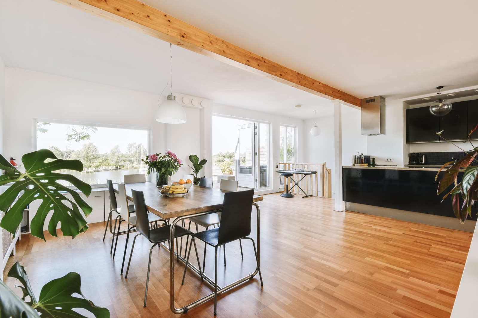 An open kitchen and dining room with a wood table and large windows