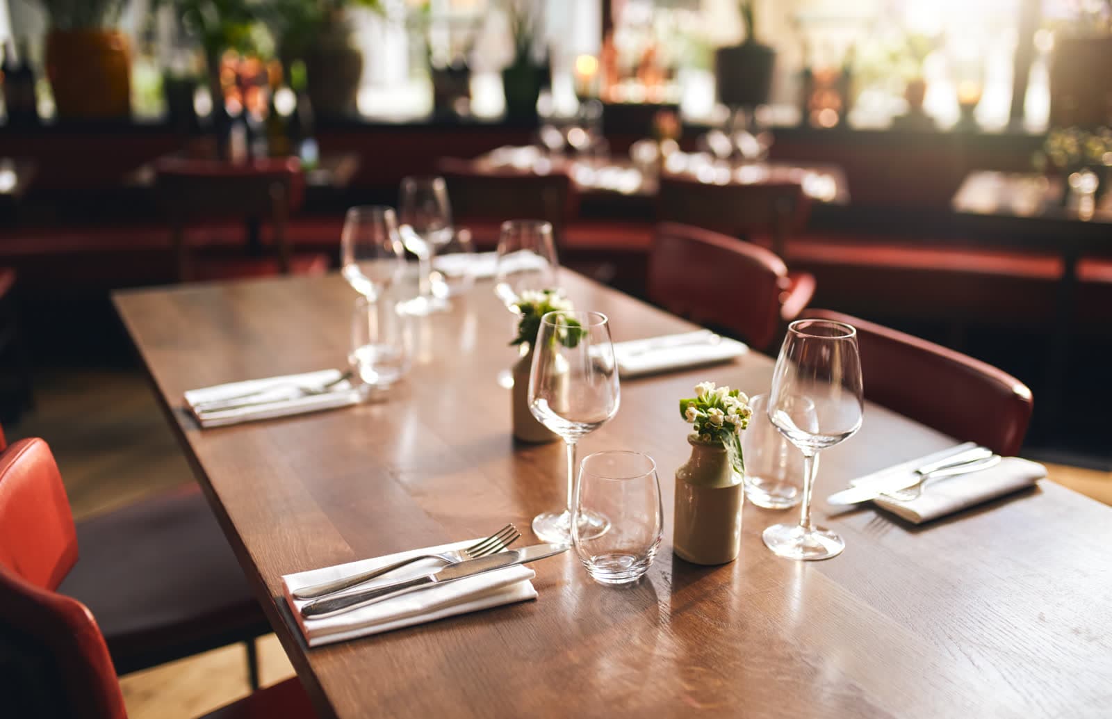 A long table set with wine glasses in a warmly lit room